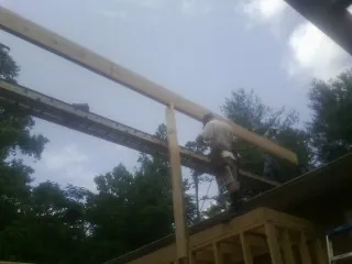 Carpenter setting a ridge beam over a new addition frame — Ice Dam Removal by Roofing Brothers in West Cornwall