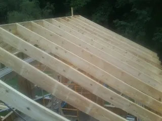 New roof rafters set over an addition before sheathing in West Cornwall