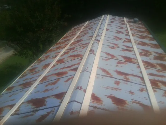 Rusted metal roof panels with new wood purlins before replacement — Storm Damage Roof Repair in West Cornwall by Roofing Brothers