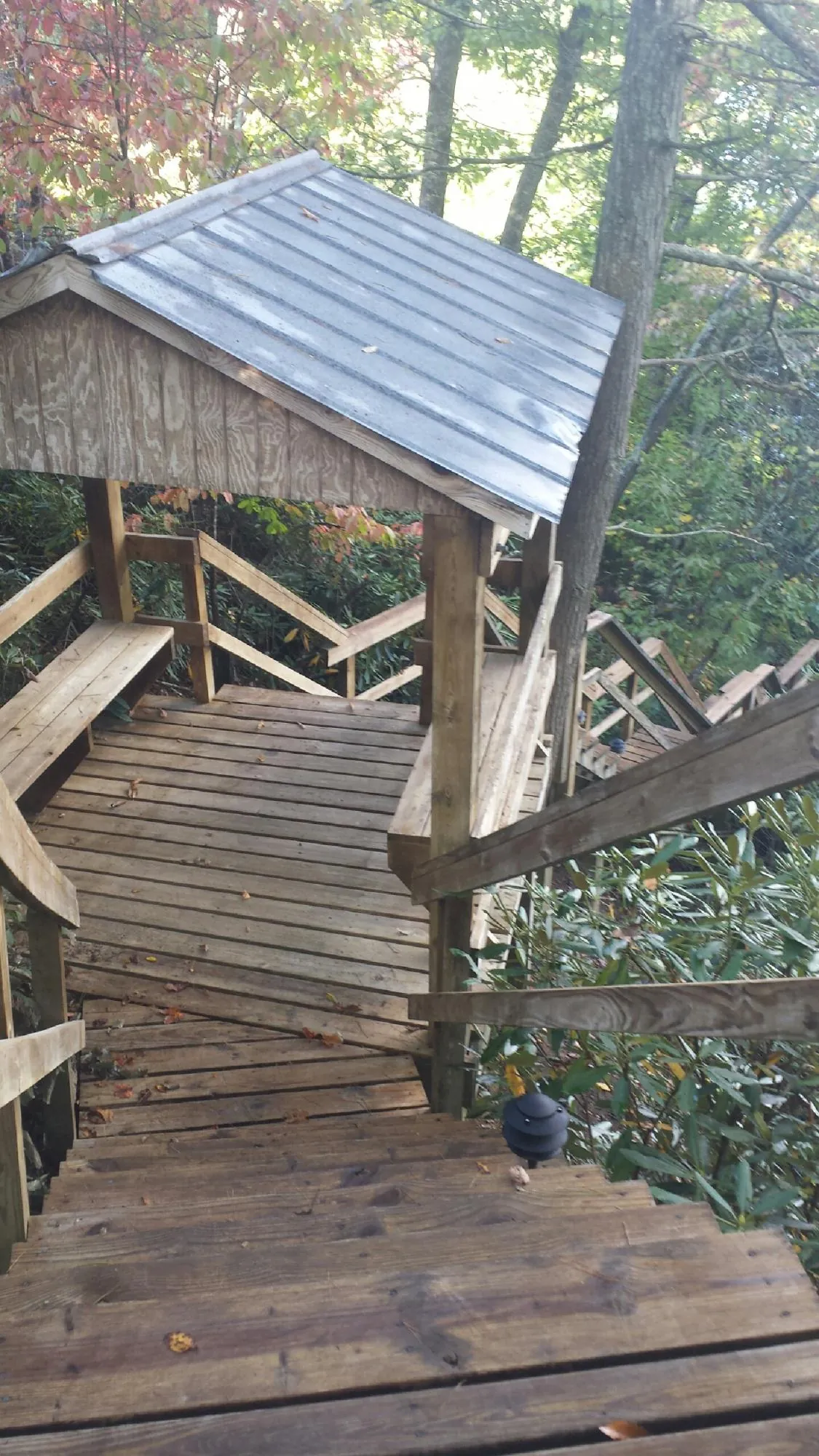 Metal roofed shelter over wooden steps on a wooded walkway — Skylight Repair & Installation work by our crew in West Cornwall