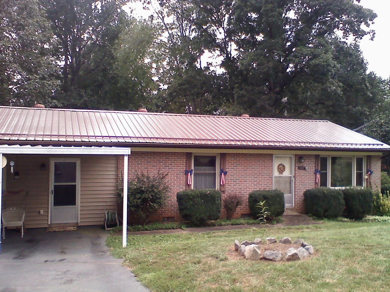 Bronze metal roof and carport on a brick ranch home — Roof Repair work by our crew in West Cornwall